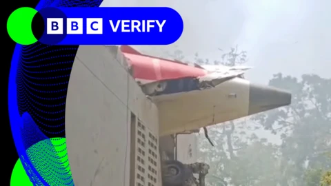 A verified screengrab from a video showing the Boeing 787-8 Dreamliner tailcone sticking out of a building in Ahmedabad