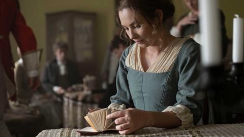 A young woman sitting at a table with a notebook