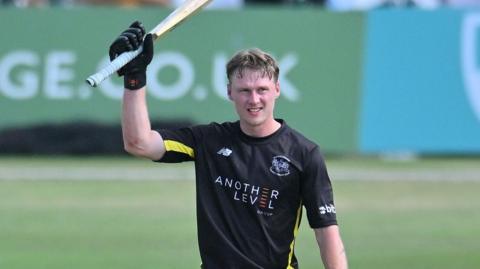 Miles Hammond holds his bat in the air