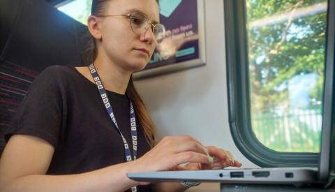 Grace Dean checks wi-fi access on her laptop as she travels on a train to Norwich