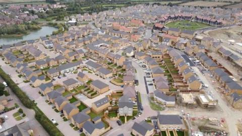 Aerial view of the town of Wixams near Bedford with newly built homes, with some still under construction.