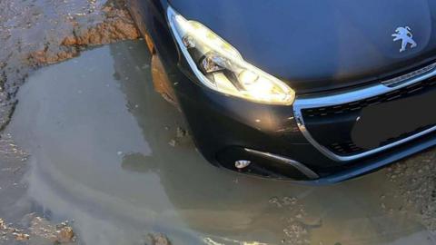 Car stuck in pothole