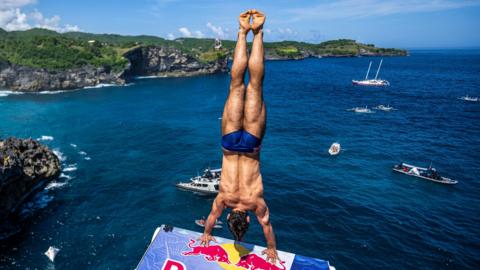 Aidan Heslop prepares to dive in Bali from handstand position