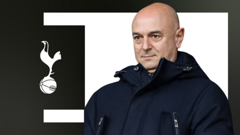Daniel Levy in front of a white background with a Tottenham crest