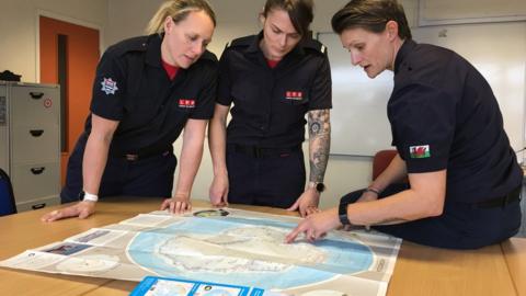 Firefighters looking at map of Antarctica