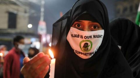 KOLKATA, WEST BENGAL, INDIA - 2022/02/11: Muslim woman holds a lit candle during a demonstration at a government-run high schools in India's Karnataka state where Muslim students were told not to wear hijabs at the institute premises.
