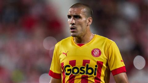 Oriol Romeu wearing a yellow and red Girona shirt