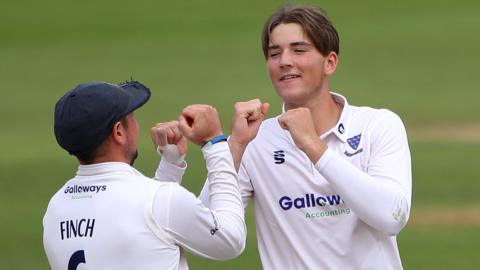 Sussex all-rounder James Coles (right) celebrates taking a wicket