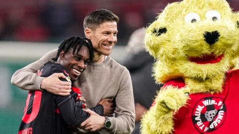 Bayer Leverkusen's Jeremie Frimpong hugs head coach Xabi Alonso after a win