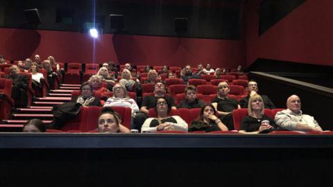 People watching the Queen's funeral in a cinema