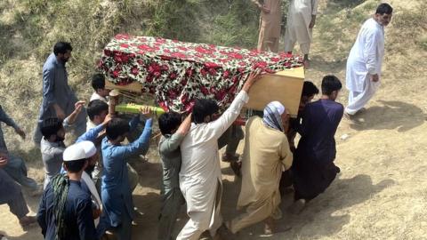 Coffin of victim in Pakistan JUI-F explosion is carried by men for burial