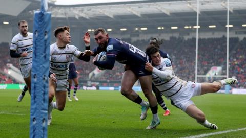 Bristol Bears and Gloucester Rugby players compete for the ball