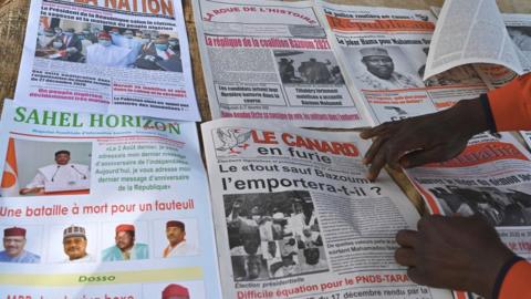 A man arranges local newspapers that he sells in a street in Niamey, Niger, on December 28, 2020, a day after Nniger's general elections