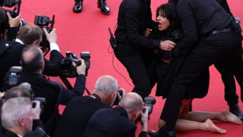 Protester on the Cannes red carpet