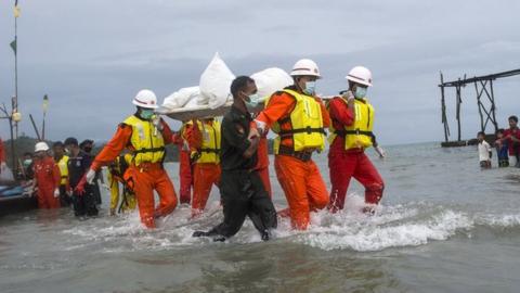 Myanmar rescuers recover a body from the plane crash in the Andaman Sea, on 8 June 2017