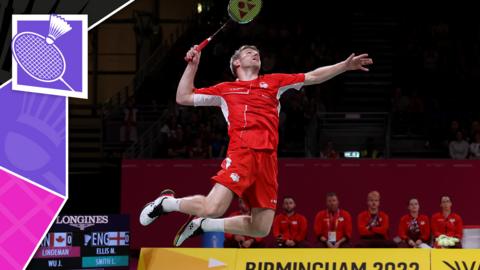 A badminton player smashes the shuttlecock