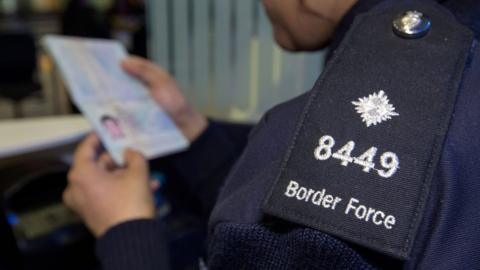 A border official checks a passport