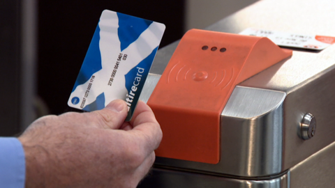 Close up of Michael Matheson, Transport Secretary, using a Scotrail card on the subway