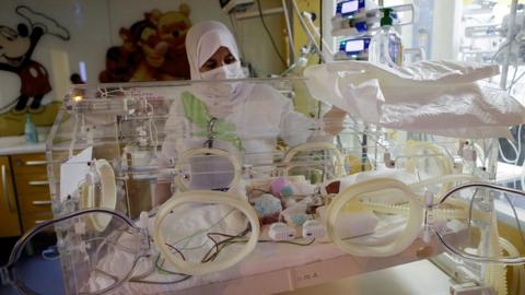 A nurse takes care of one of the newborn nonuplets, lying in an incubator, at the private clinic of Ain Borja in Casablanca, Morocco May 5, 2021