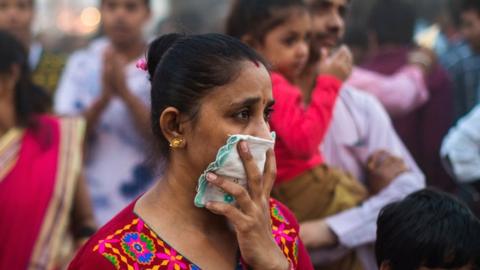 Woman shields her nose from smoke