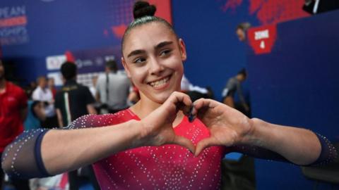 Jessica Gadirova makes a heart shape with her hands