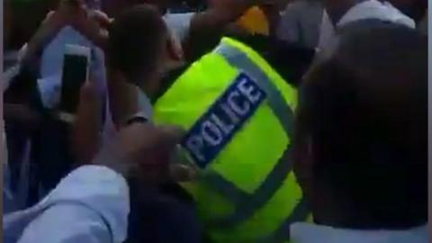 Policeman dancing with cricket fans in Luton