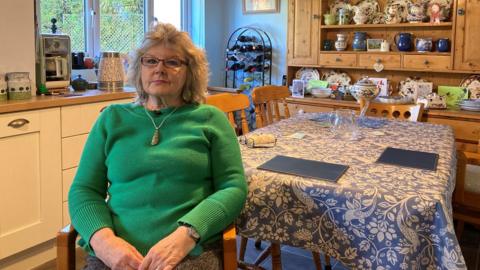 Mel Lawrence sitting in her home