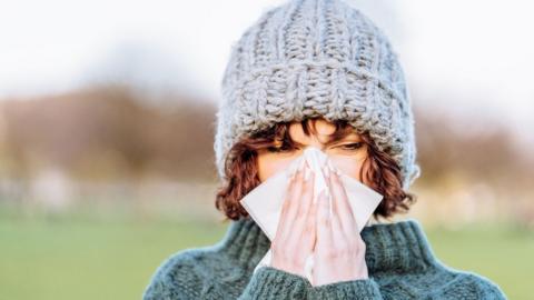 Woman blowing her nose