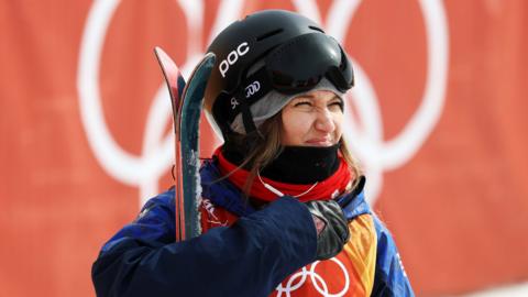 Rowan Cheshire holding her skis at the Pyeongchang Winter Olympics