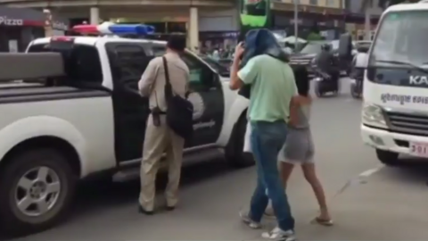 Video footage showing a covered Clive Cressy being led out to a police car in Cambodia