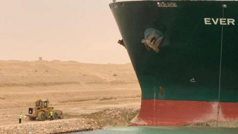 Workers try to free the MC Ever Given container ship which ran aground in Suez Canal in Egypt