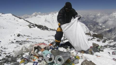 This picture taken on May 23, 2010 shows a Nepalese sherpa collecting garbage, left by climbers, at an altitude of 8,000 metres during the Everest clean-up expedition at Mount Everest. A group of 20 Nepalese climbers, including some top summiteers collected 1,800 kilograms of garbage in a high-risk expedition to clean up the world's highest peak