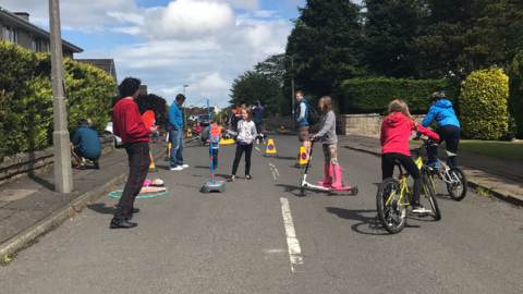 Children playing games and cycling in the street