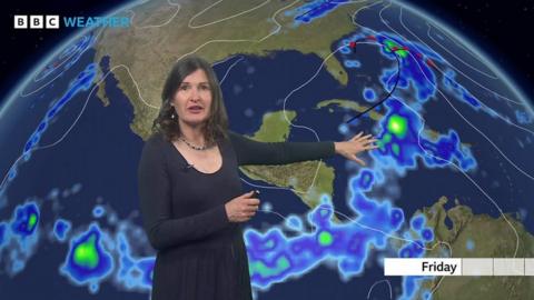 Helen Willetts standing in front of a weather map of the Carribean