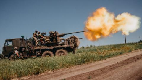 Ukrainian soldiers shoot rounds into Russian positions with an anti-aircraft cannon placed on a truck, outside Bakhmut, Ukraine on 19 June