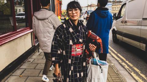 Image of Yumiko wearing her kimono standing in the street.