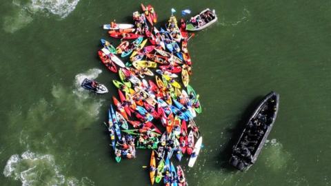 An aerial shot of police boats approaching the blockade