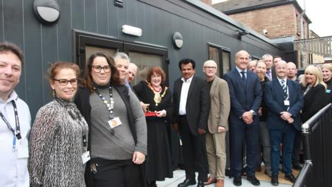 Supporters gather outside the new grey modular building as the ribbon is cut for the Ipswich Regents new facilities