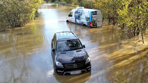 A car and a van stranded in floodwater in the road