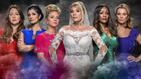 The Six women involved in EastEnders storyline. From left to right it's Stacey wearing a red dress, Suki wearing a blue dress, Linda wearing a pink dress, Sharon wearing a white wedding dress with hands on hips, Denise wearing a green outfit and Kathy wearing a purple dress. All the women have a stern expression. There is coloured smoke surrounding them in the background.