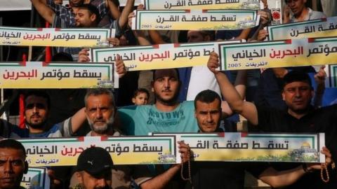 Palestinians in Gaza City hold banners denouncing the US plan. Photo: 25 June 2019