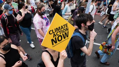 Climate change protestors are seen marching and changing as they carry placards on November 06, 2021 in Melbourne, Australia.