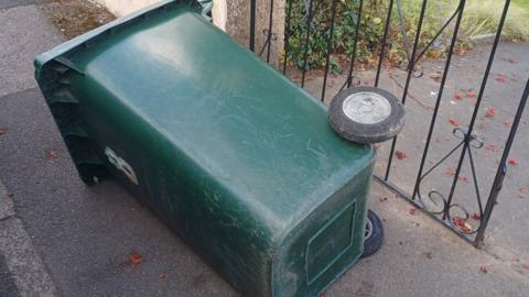 Bin on its side on the pavement