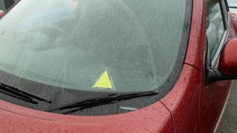 A picture of the yellow triangle on a car window to alert emergency teams to a driver's medical advice