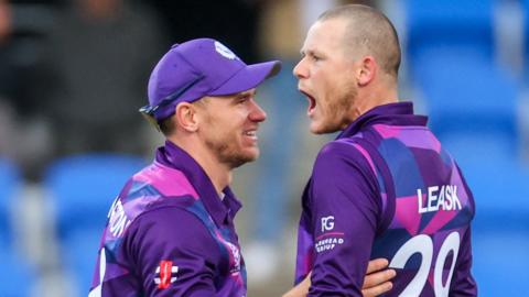 Scotland's Michael Leask (R) celebrates with team captain Richie Berrington after dismissing West Indies captain Nicholas Pooran