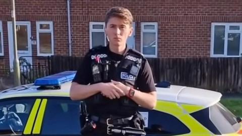 Police officer stood next to car