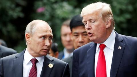 U.S. President Donald Trump and Russia"s President Vladimir Putin talk during the family photo session at the APEC Summit in Danang, Vietnam 11 November 2017.