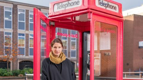 Dr Sarah Jackson with the dial-a-poem phone booth