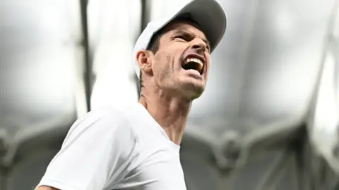 Close-up image of Andy Murray with the Centre Court roof in the background
