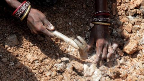 Close-up of the hands of an Indian woman working, collecting mica at a scrap mine in Jharkhand